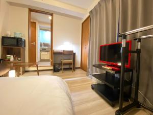 a hotel room with a bed and a flat screen tv at マルチステイ大阪京橋22 in Osaka
