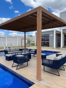 un pabellón con mesas y sillas junto a una piscina en Condomínio Indianopolis a 1,4km do North Shopping, en Caruaru