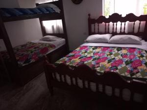 1 dormitorio con 2 literas y edredón en Los Tres Leones, en Salento