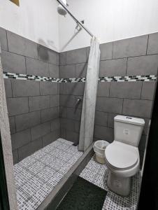 y baño con aseo y ducha. en Casa González en Santiago Atitlán