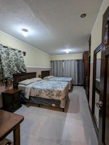 1 dormitorio con 2 camas y mesa. en Casa González en Santiago Atitlán