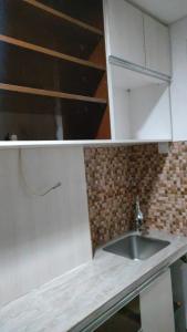 a kitchen with a sink and a counter top at Apartemen Skylounge Makassar in Manda