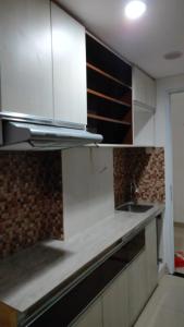 a kitchen with white cabinets and a sink at Apartemen Skylounge Makassar in Manda