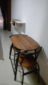 een houten tafel bovenop een tafel bij Apartemen Skylounge Makassar in Manda