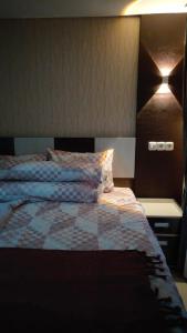 a bedroom with a bed and a nightstand with a bed sidx sidx at Apartemen Skylounge Makassar in Manda