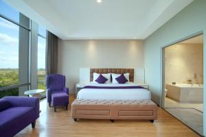 a bedroom with a bed and a bath tub at Platinum Hotel & Convention Hall Balikpapan in Balikpapan