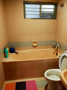a bathroom with a tub and a toilet and a sink at R2L5Y Room 1 with balcony and bathroom in Bentong