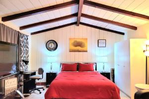 een slaapkamer met een rood bed en een klok aan de muur bij Guest house-perfect getaway - relaxing space in Temple City