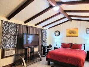 een slaapkamer met een rood bed en een flatscreen-tv bij Guest house-perfect getaway - relaxing space in Temple City