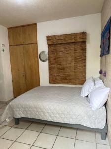 łóżko z białą pościelą i poduszkami w pokoju w obiekcie Oasis Casa 120 w mieście Santa Anita