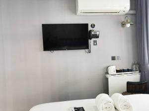 Zimmer mit einem Flachbild-TV an der Wand in der Unterkunft Narawad Boutique Hotel in Bangkok