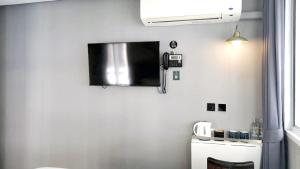 einen Flachbild-TV an der Wand in einem Zimmer in der Unterkunft Narawad Boutique Hotel in Bangkok