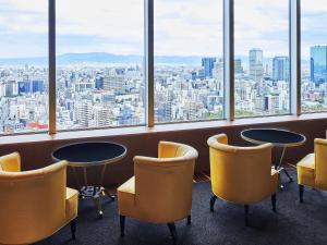 a room with two tables and chairs and windows at Imperial Hotel Osaka in Osaka