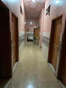 pasillo de un baño con puertas y suelo de baldosa en OYO 81144 Royal Guest House, en Jīnd