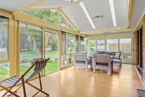 a screened in porch with chairs and a couch at Waterfront Pet-Friendly Abode - Toukley NSW in Toukley