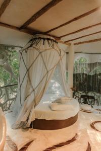uma cama num quarto com uma rede em Ikalar em Akumal