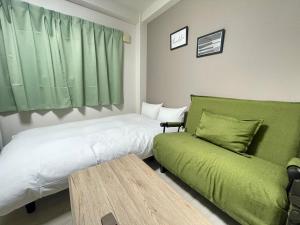 um quarto com uma cama, um sofá e uma mesa em マルチステイ大阪京橋32 em Osaka