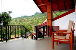 a porch with a table and chairs on a balcony at Nature First Hotel in Nuwara Eliya