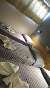 Una cama en una habitación con almohadas. en Hotel Turis en San Rafael