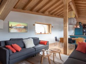 ein Wohnzimmer mit einem blauen Sofa und roten Kissen in der Unterkunft Chalet Les Gets, 5 pièces, 8 personnes - FR-1-671-245 in Les Gets