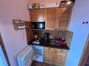 a small kitchen with a sink and a microwave at Chalet Mitoyen au Cœur des Angles, Proche Pistes et Commerces, 2 Ch, Mezzanine, Balcon - FR-1-593-98 in Les Angles