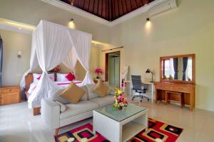 - un salon avec un canapé, un lit et un bureau dans l'établissement Ubud Hillside by Sari Sasih (PROMO), à Ubud