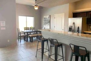 a kitchen with a bar with chairs and a table at Havasu Retreat! Pool, Spa, Gym & View in Lake Havasu City