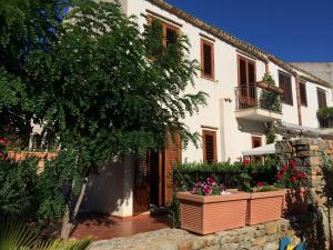 a white building with flowerpots in front of it at Villa Giuliana in San Vito lo Capo
