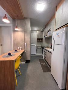 uma cozinha com um frigorífico branco e uma mesa com cadeiras amarelas em Novinho Allianz Parque em São Paulo