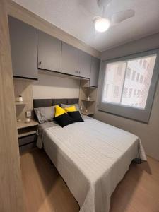 um quarto com uma cama com almofadas amarelas e pretas em Novinho Allianz Parque em São Paulo