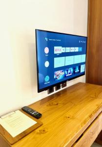 TV de pantalla plana con escritorio de madera en Charlie Guest House en Nusa Dua