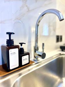 two bottles of soap sitting on a kitchen sink at Charlie Guest House in Nusa Dua