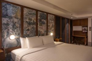 Un dormitorio con una cama grande con un mural de pared. en Payaa Hotel, en Pattaya central