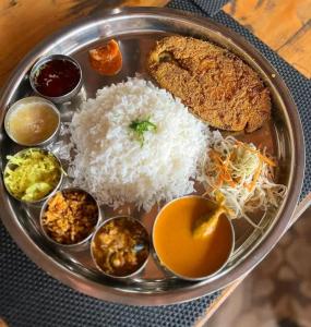 a plate of food with rice and other foods at Holiday Tourisms Group of Homestay Food Scuba Diving Boating Watersports-Tarkarli-Devbag Beach in Bhogwe