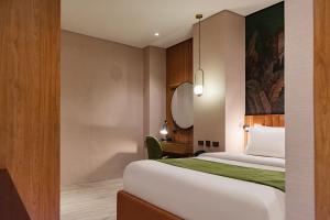 una camera d'albergo con letto e specchio di Ironwood Hotel a Tacloban