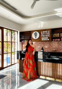 a woman in a red dress standing in front of a bar at LITTLE PHU QUOC STUDIO in Phu Quoc