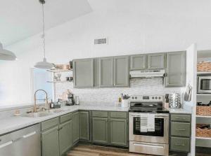una cocina con armarios verdes y fregadero en Home away from home w/ private pool!, en Glendale