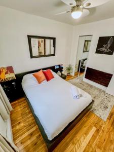 een slaapkamer met een bed met witte lakens en oranje kussens bij Barel Home Residence in Longueuil
