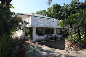 a white house with a balcony on top of it at La Casa Blanca Binoclutan in Botolan