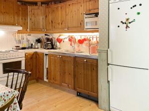 cocina con armarios de madera y nevera blanca en Holiday home EKSJÖ II en Eksjö