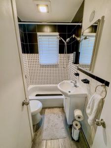 een kleine badkamer met een toilet en een wastafel bij Barel Home Residence in Longueuil