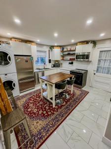 a large kitchen with a wooden table and a stove at Barel Home Residence in Longueuil