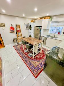 a kitchen with a wooden table and chairs on a rug at Barel Home Residence in Longueuil