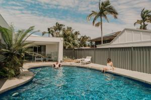 two people sitting in the swimming pool of a house at Quail Cove in Gold Coast