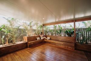 a woman sitting on a bench in a room with plants at Quail Cove in Gold Coast