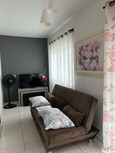 a living room with a couch and a television at Residencial Lara in Itapema