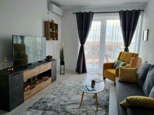 a living room with a couch and a television at Ana&Patrick FriendlyApartment in Oradea
