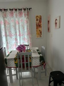 伊塔佩馬的住宿－Residencial Lara，餐桌,两把椅子和一张鲜花桌子