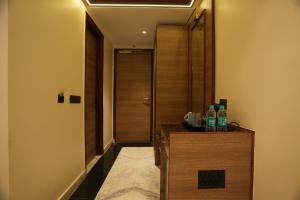 a hallway with a door and two bottles on a counter at Lime Tree Hotel and Banquet Greater Noida in Greater Noida