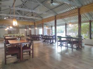 a dining room with wooden tables and chairs at Jironi Resort in Charduār